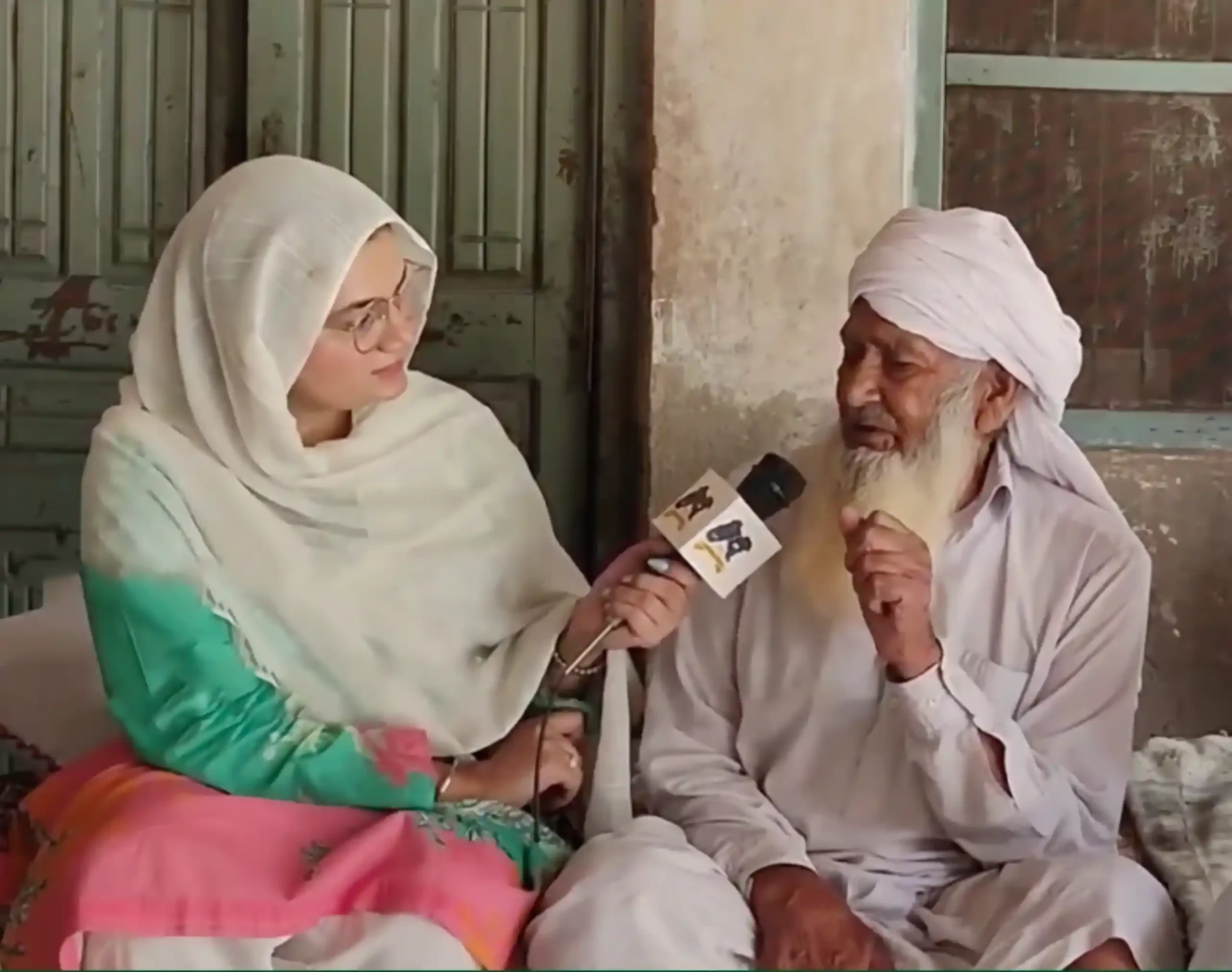 Purva Masaud, the director of Jeevay Sanjha Punjab, conducting an oral history interview with a 1947 Partition survivor in a village setting.